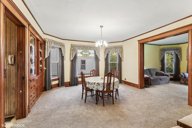 dining room featuring light carpet, an inviting chandelier, and ornamental molding