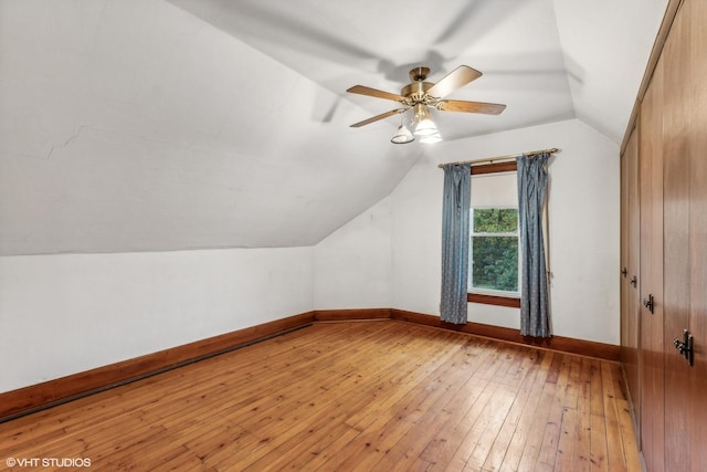 additional living space with ceiling fan, wood-type flooring, and vaulted ceiling