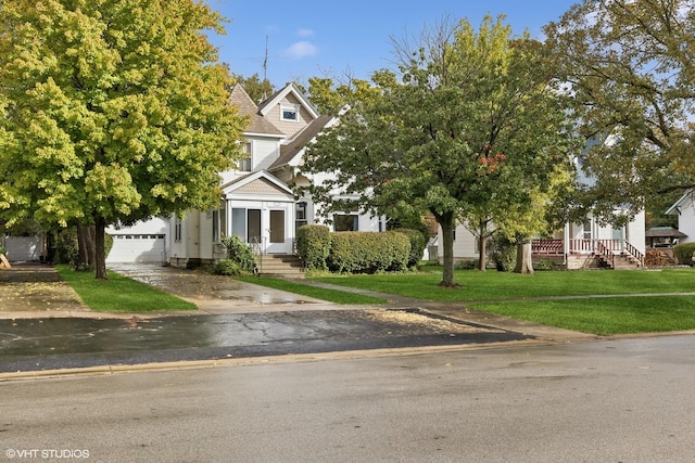 view of property hidden behind natural elements with a garage and a front yard