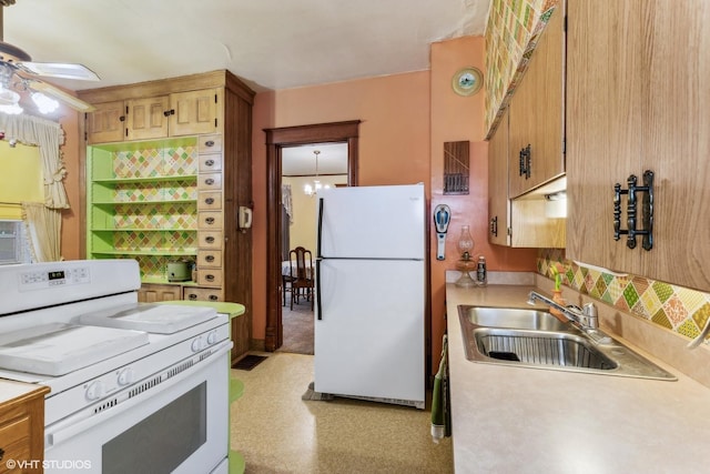 kitchen featuring ceiling fan with notable chandelier, sink, and white appliances