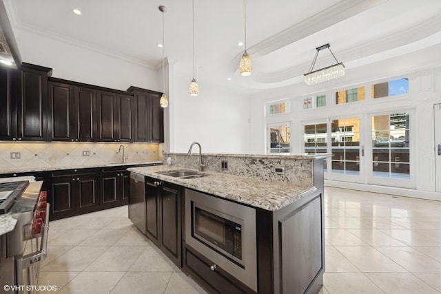 kitchen with stainless steel appliances, pendant lighting, light tile patterned flooring, and a sink