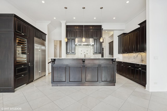 kitchen with pendant lighting, stainless steel built in refrigerator, a kitchen island, and exhaust hood