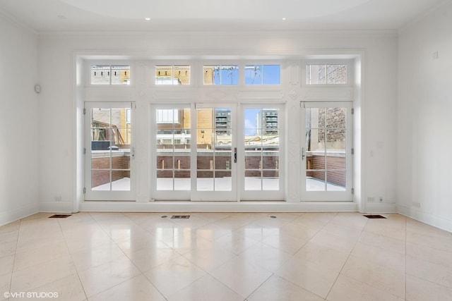 entryway featuring a healthy amount of sunlight, crown molding, and baseboards