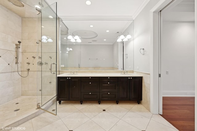 bathroom featuring crown molding, double vanity, recessed lighting, a stall shower, and a sink