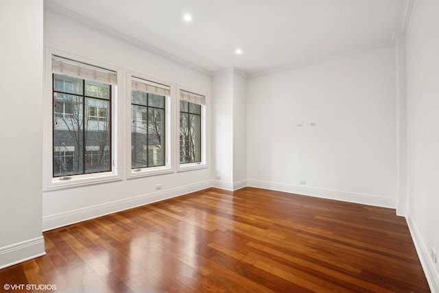 spare room with ornamental molding, recessed lighting, dark wood finished floors, and baseboards