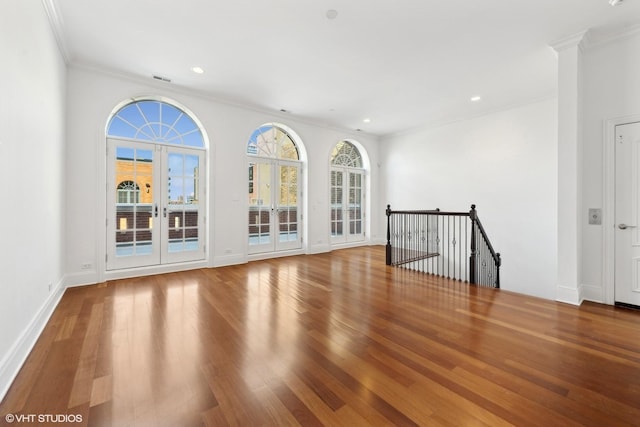 spare room with recessed lighting, crown molding, baseboards, and wood finished floors