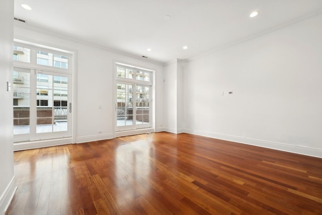 unfurnished room with recessed lighting, visible vents, ornamental molding, wood finished floors, and baseboards