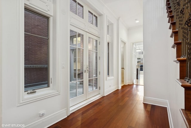 hallway featuring ornamental molding, french doors, dark wood finished floors, and baseboards