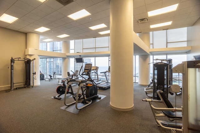 workout area with a drop ceiling, a towering ceiling, and carpet floors