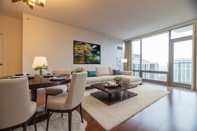 living room with hardwood / wood-style flooring, a wall of windows, and a healthy amount of sunlight