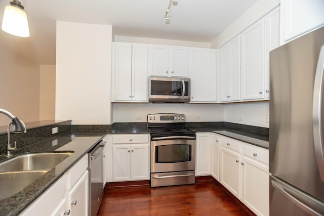 kitchen with stainless steel appliances, white cabinetry, and sink