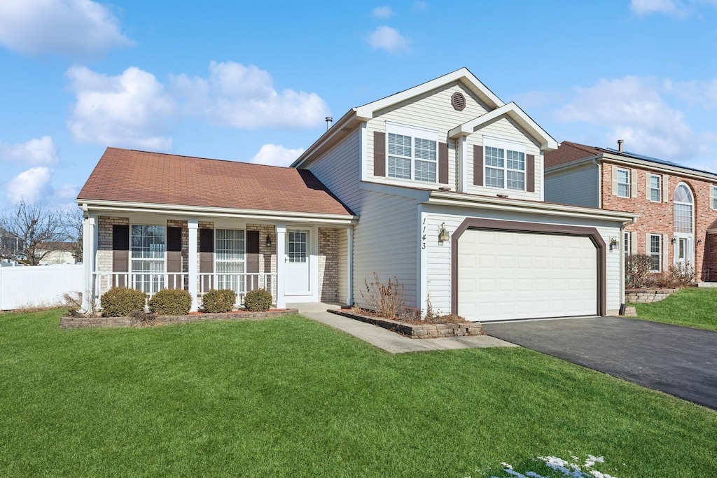 view of front of property featuring a garage, a front lawn, and a porch