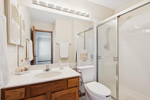 bathroom with toilet, vanity, and an enclosed shower