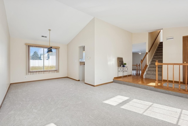 unfurnished living room featuring carpet and vaulted ceiling