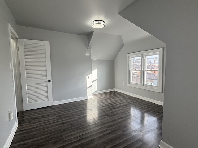 additional living space with dark hardwood / wood-style flooring and vaulted ceiling