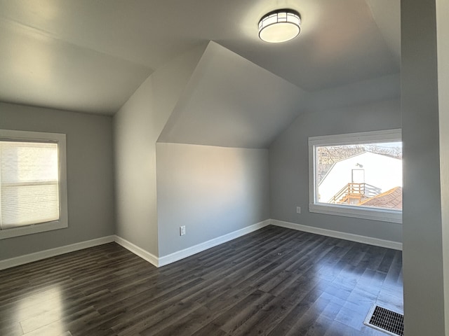 bonus room with vaulted ceiling and dark hardwood / wood-style floors