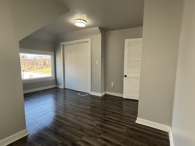 unfurnished bedroom featuring a closet and dark hardwood / wood-style floors