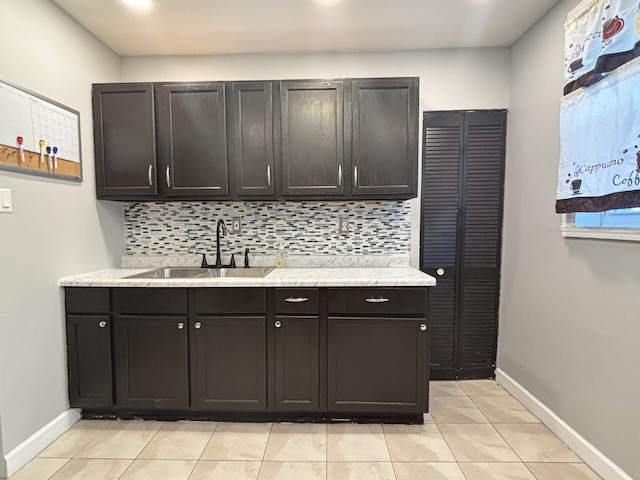 kitchen with light tile patterned flooring, decorative backsplash, and sink