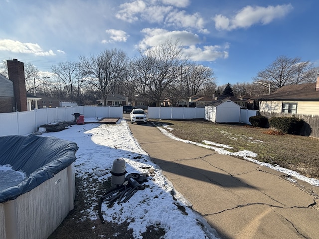 yard covered in snow with a shed