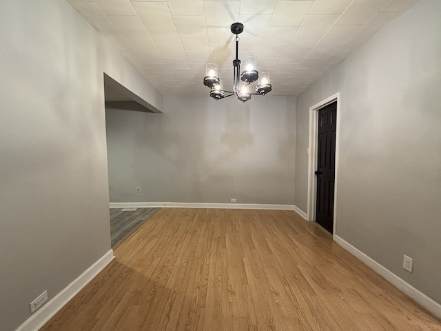 unfurnished dining area featuring light hardwood / wood-style floors and a chandelier