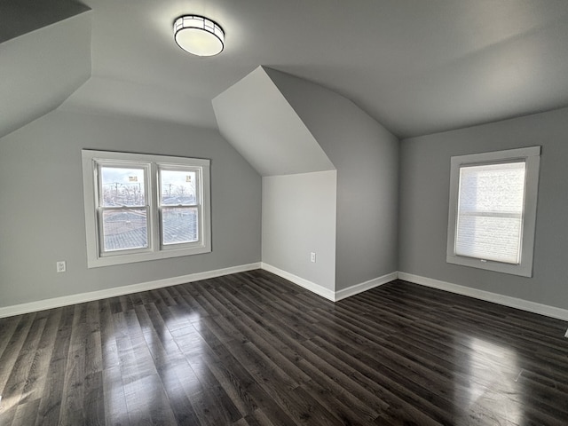 bonus room with lofted ceiling and dark hardwood / wood-style floors