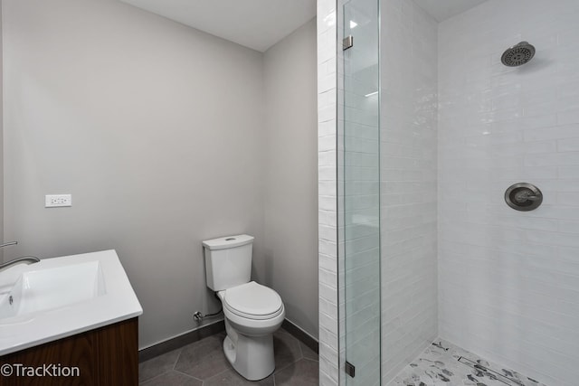 bathroom with an enclosed shower, vanity, tile patterned floors, and toilet