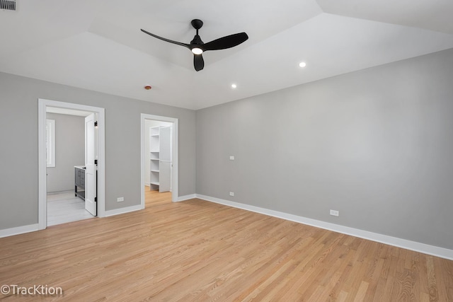 unfurnished bedroom with ceiling fan, light wood-type flooring, connected bathroom, a walk in closet, and a closet