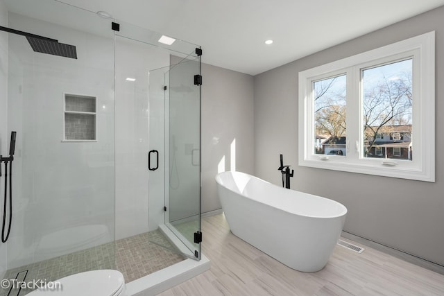 bathroom with toilet, wood-type flooring, and separate shower and tub