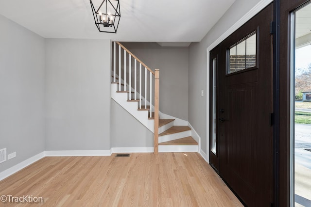 foyer entrance with a chandelier and light hardwood / wood-style flooring