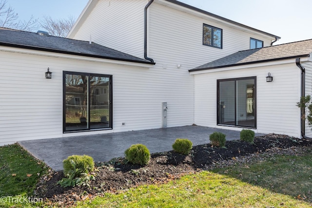 rear view of property with a lawn and a patio