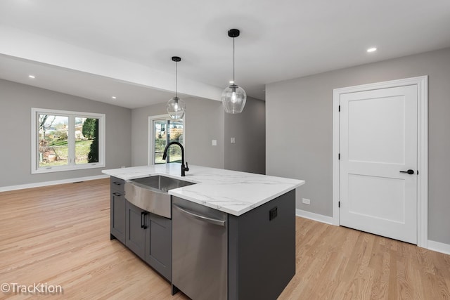 kitchen with lofted ceiling, pendant lighting, stainless steel dishwasher, sink, and a kitchen island with sink