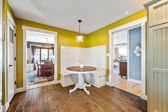 unfurnished dining area featuring a textured ceiling and dark hardwood / wood-style floors