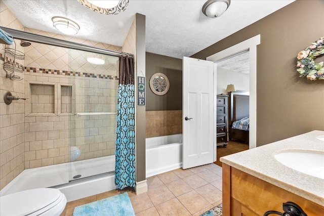 bathroom with tile patterned flooring, tiled shower, toilet, a textured ceiling, and vanity