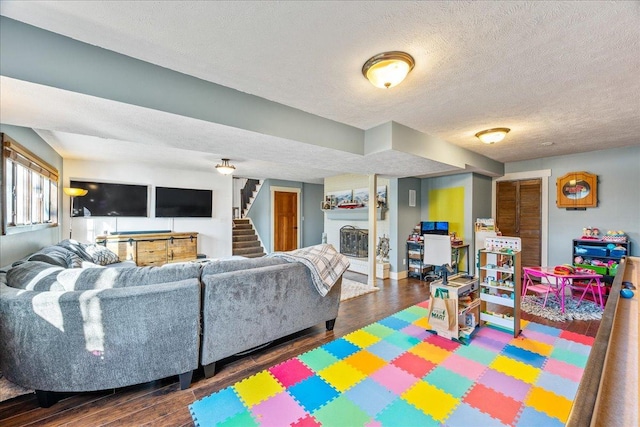 living room featuring dark wood-type flooring and a textured ceiling