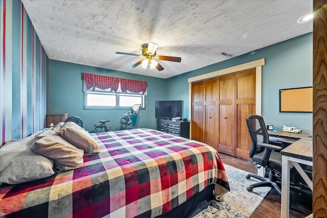 bedroom featuring hardwood / wood-style flooring, a textured ceiling, a closet, and ceiling fan