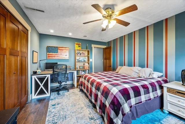 bedroom featuring ceiling fan, dark hardwood / wood-style floors, and a textured ceiling