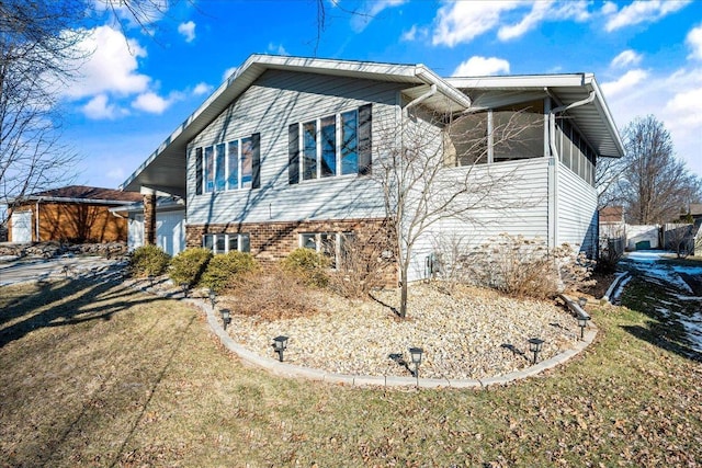 view of side of property featuring a yard and a sunroom