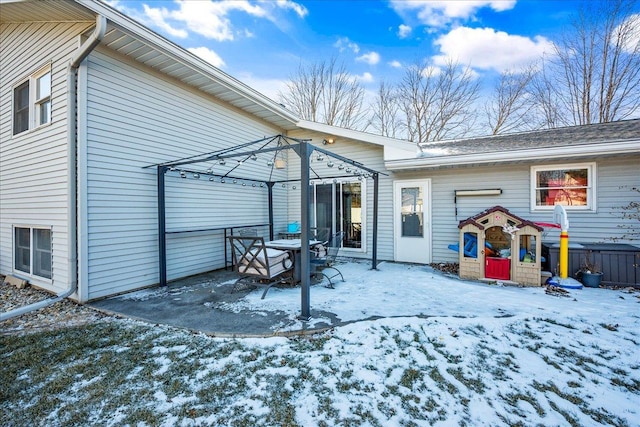 snow covered back of property with a gazebo