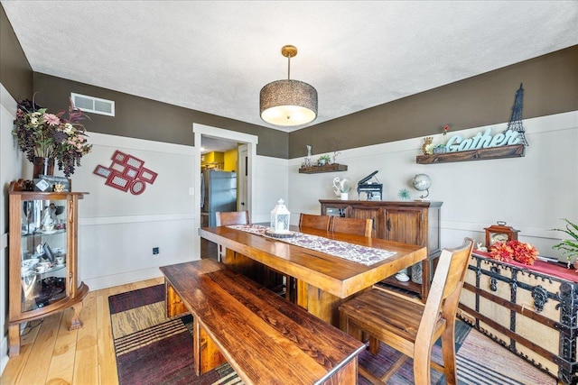 dining room with hardwood / wood-style floors and a textured ceiling