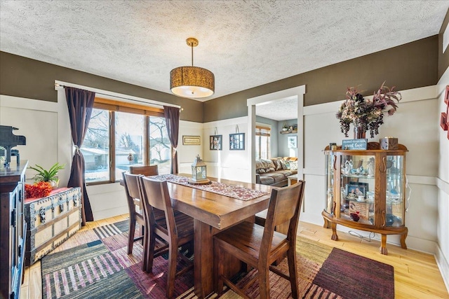 dining room with light hardwood / wood-style floors and a textured ceiling