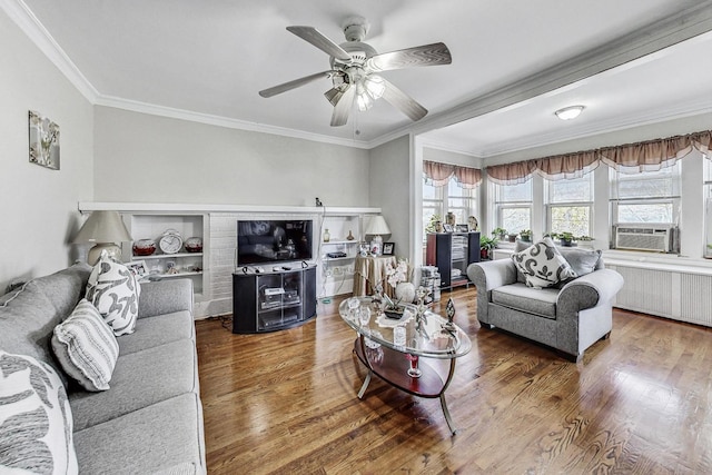 living room featuring radiator heating unit, hardwood / wood-style flooring, cooling unit, ornamental molding, and ceiling fan