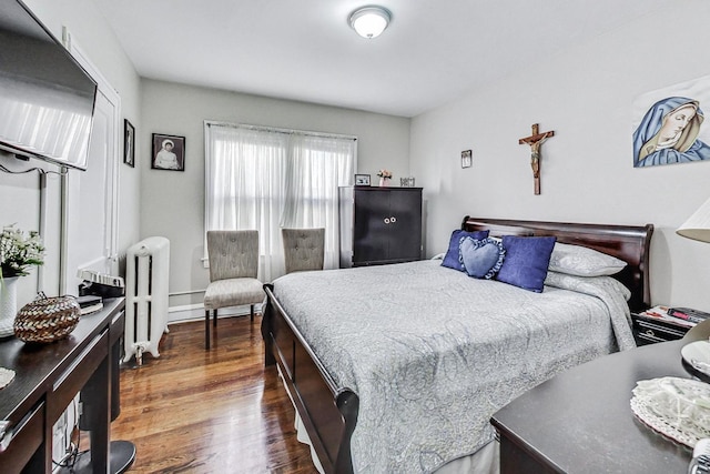 bedroom featuring radiator heating unit and dark wood-type flooring