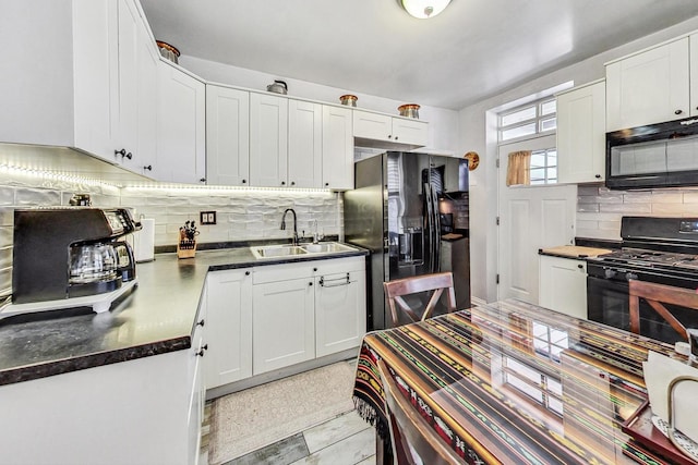 kitchen featuring black appliances, white cabinets, decorative backsplash, and sink