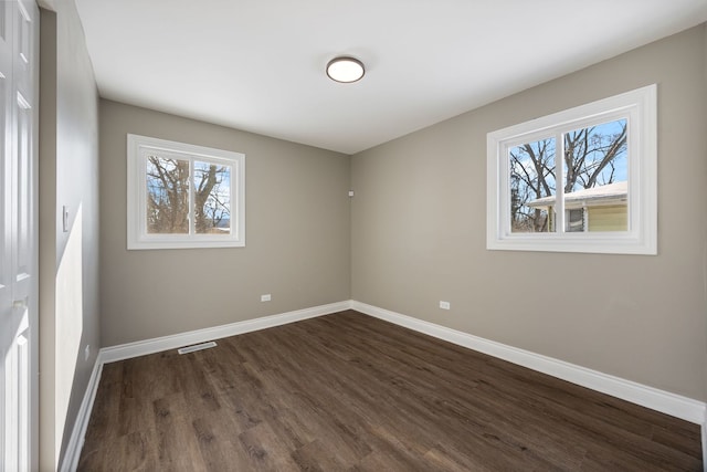 empty room with dark hardwood / wood-style flooring