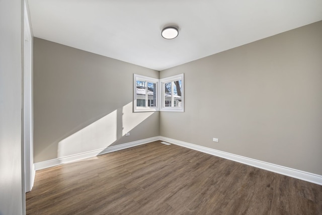 unfurnished room with dark wood-type flooring