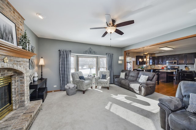 living room featuring a brick fireplace, light colored carpet, and ceiling fan