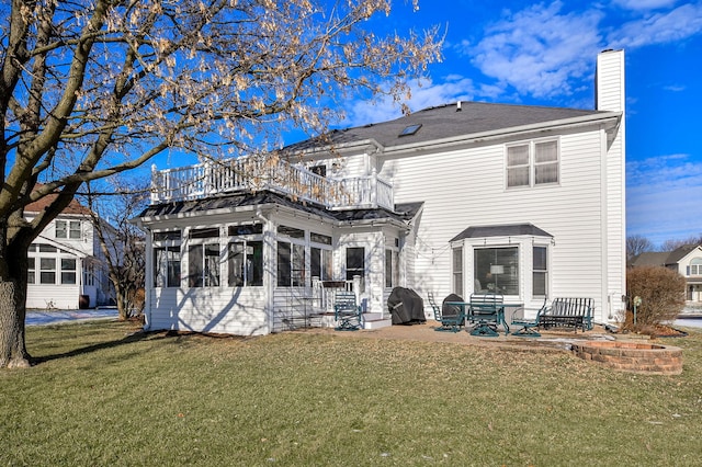 back of house featuring a yard, a sunroom, a patio, and a balcony