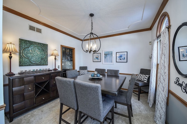 dining room with ornamental molding, light carpet, a notable chandelier, and a textured ceiling