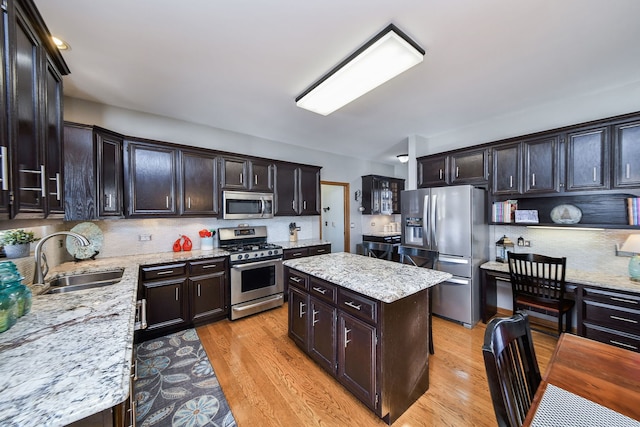 kitchen featuring sink, dark brown cabinets, stainless steel appliances, and a center island