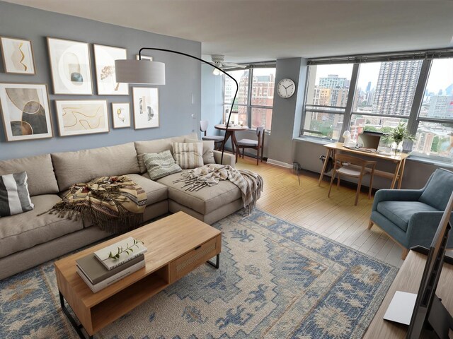 living room with wood-type flooring and ceiling fan